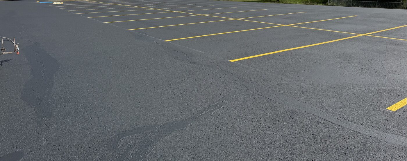 Freshly sealcoated commercial parking lot with bright yellow striping